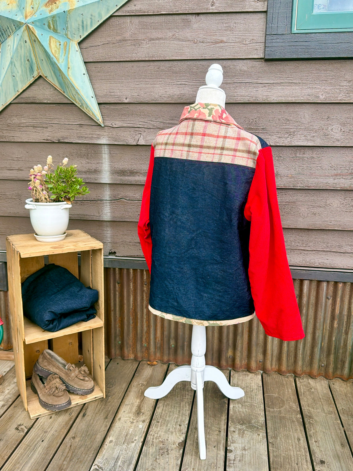 Back of the denim barn coat with red corduroy sleeves on a mannequin showing the denim back and red corduroy sleeves