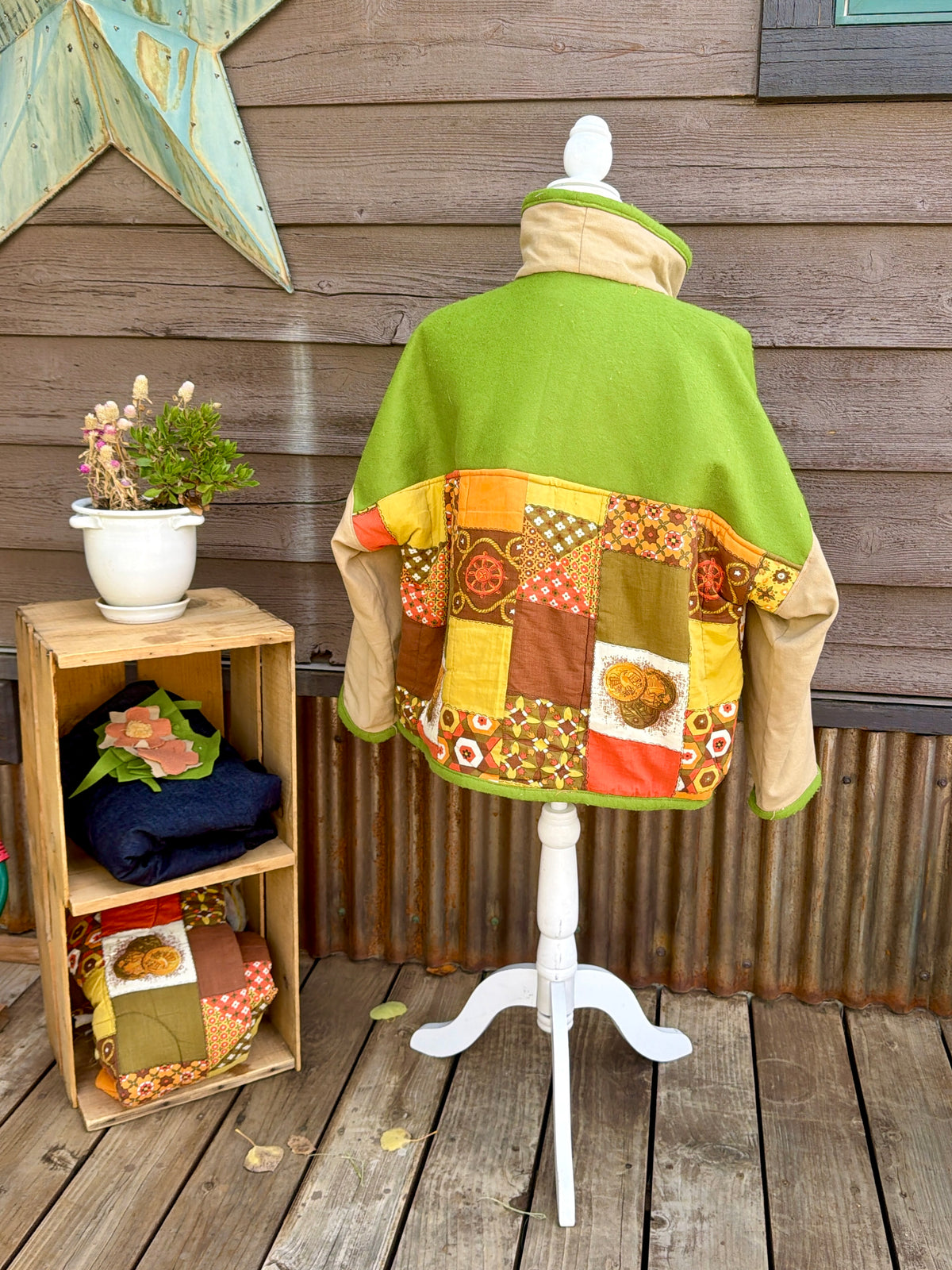 Back of the green and tan sleeping bag boxy chore coat on a mannequin showing the quilted sleeping bag back