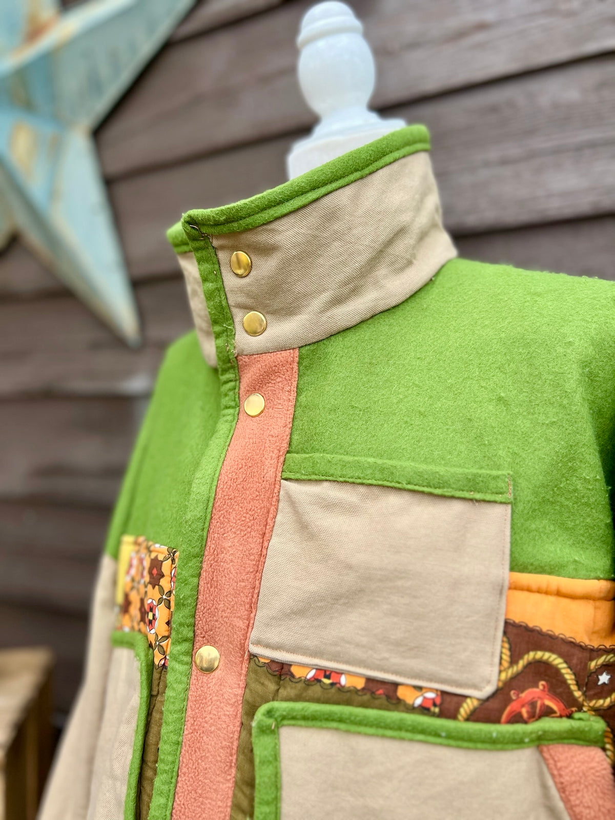 Close-up of the snap collar, shown standing up on the green and tan sleeping bag boxy chore coat
