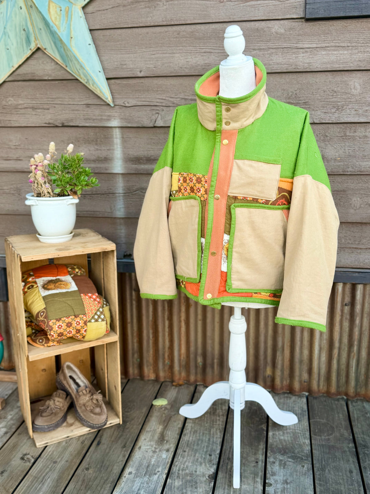 Green and tan sleeping bag boxy chore coat on a mannequin, front view