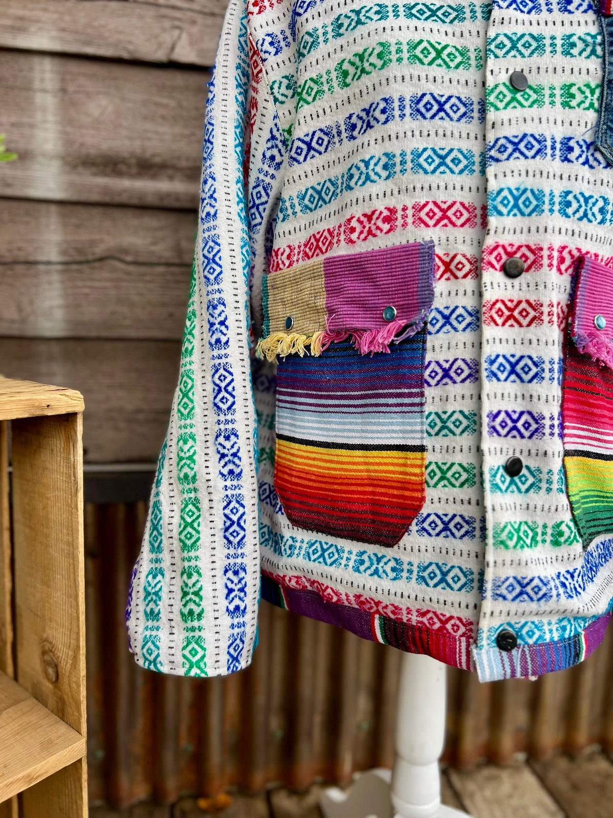 Close-up of bold multicolor woven stripe blanket on the multicolor woven stripe blanket camp coat