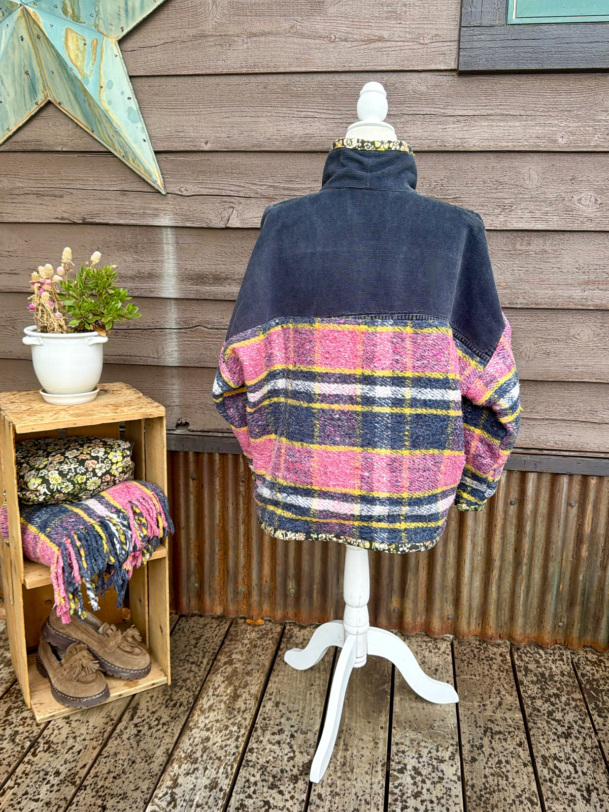 Back of the pink plaid wool blanket boxy chore coat on a mannequin showing the plaid wool back with navy corduroy yoke