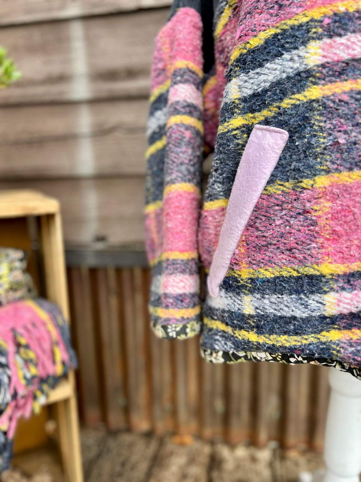 Hem and sleeve of the pink plaid wool blanket boxy chore coat showing the floral sheet lining