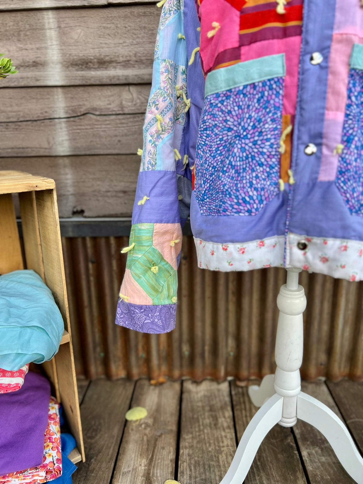 Close-up of purple patchwork quilt with yarn tassels on the purple patchwork vintage quilt camp coat