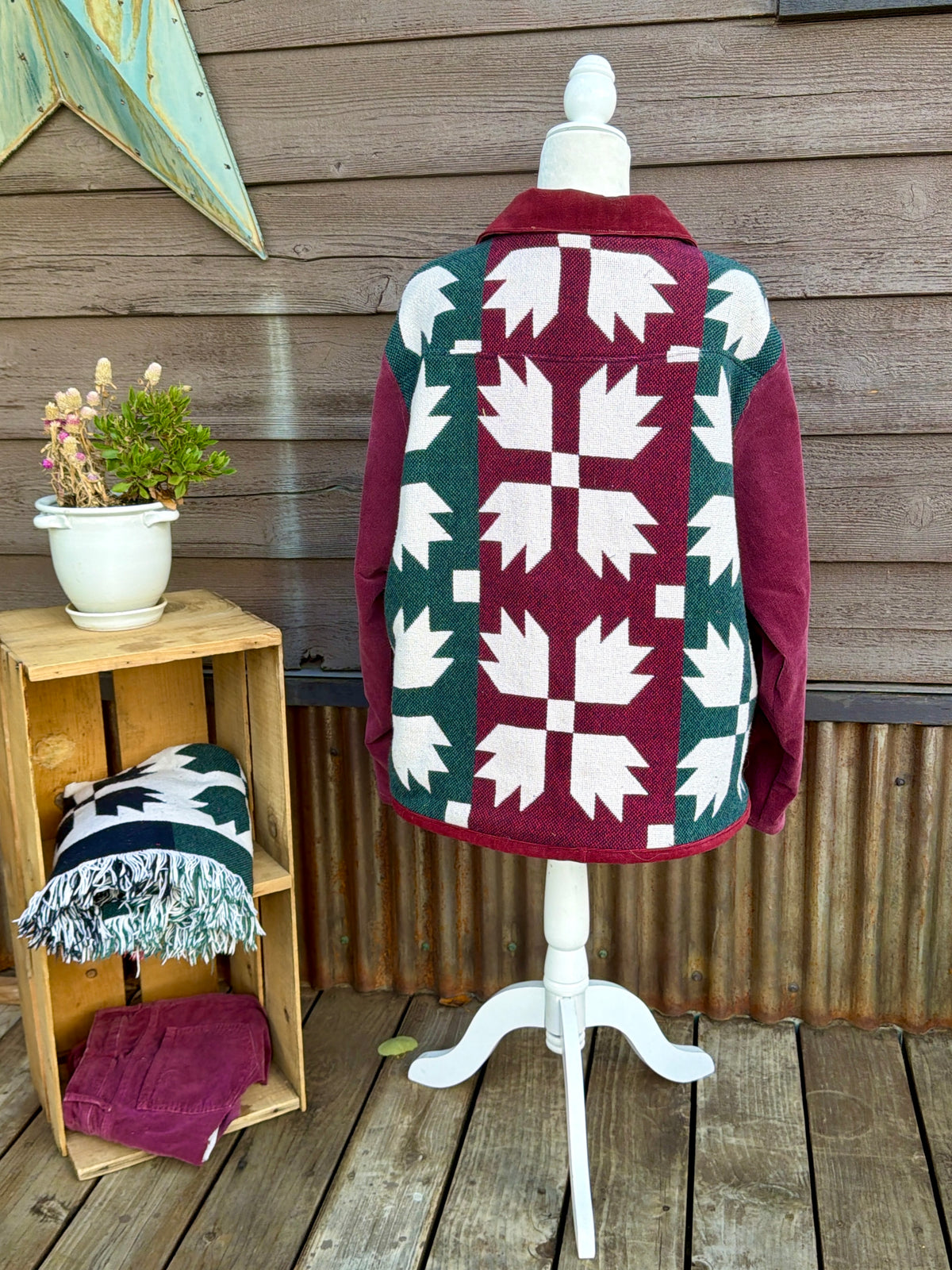 Back of the Southwestern blanket camp coat on a mannequin showing the star print blanket back and burgundy sleeves
