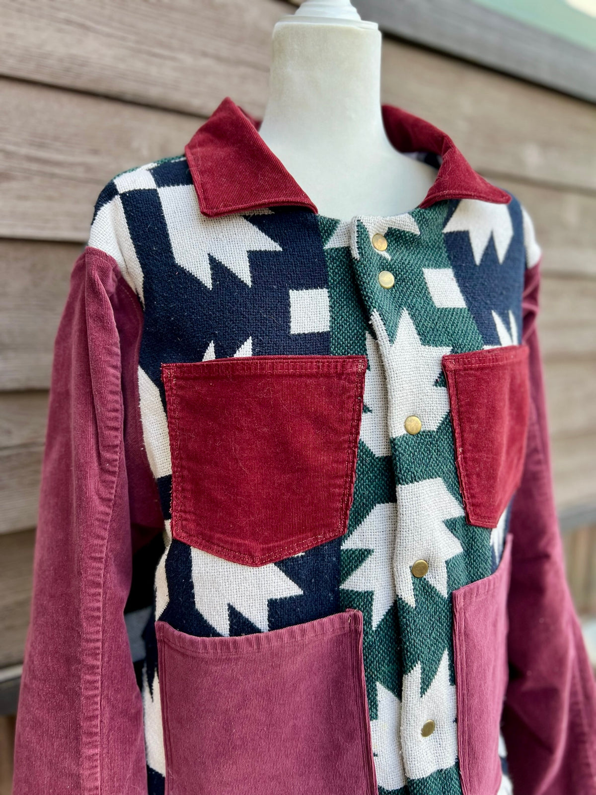 Close-up of the burgundy corduroy chest pockets on the Southwestern blanket camp coat with burgundy corduroy