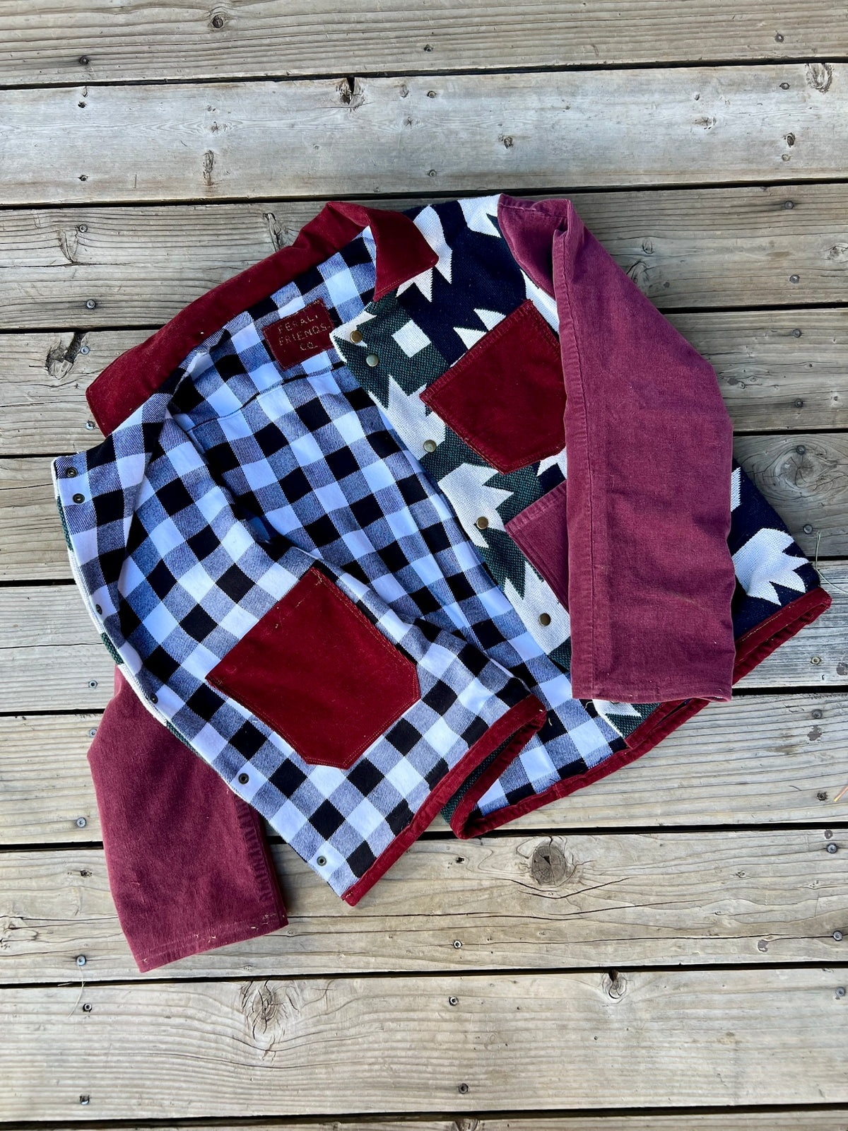Inside of the Southwestern blanket camp coat showing the black and white plaid flannel lining and inside pocket