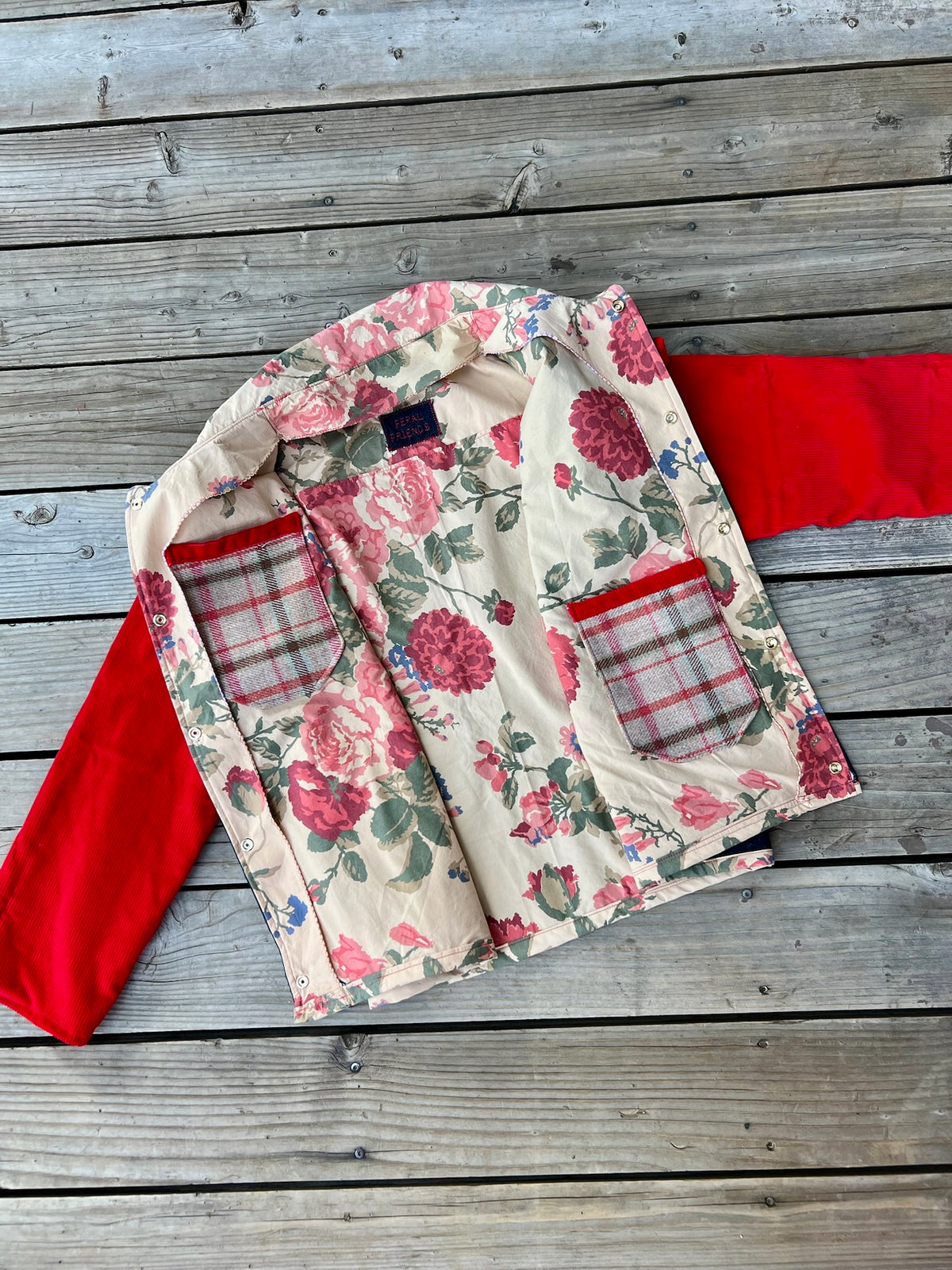 Inside of the denim barn coat with red corduroy sleeves showing the floral bedsheet lining
