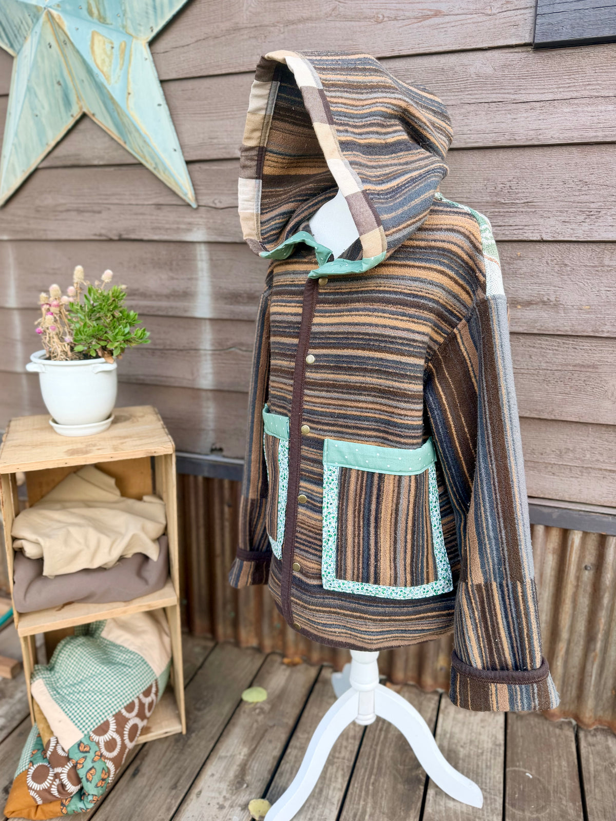 Striped horse blanket hooded coat on a mannequin, front hood up view