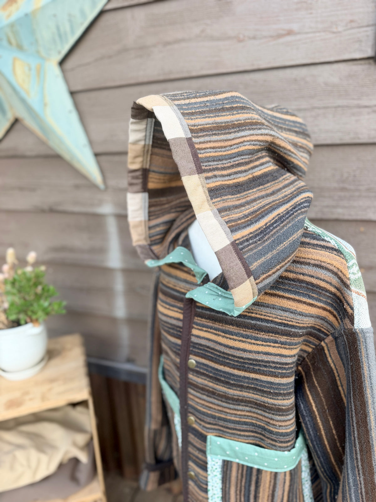 Close-up of the hood and snap front on the striped horse blanket hooded coat hood up