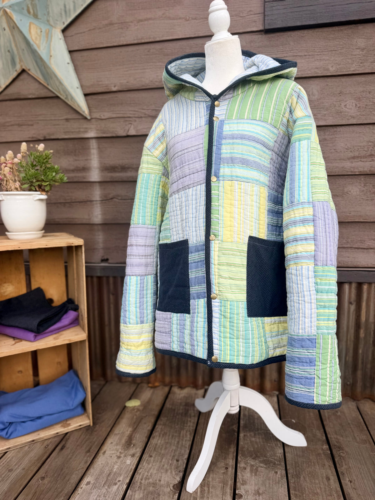 Close-up of green, yellow, blue and purple striped quilt squares on the striped quilt hooded coat