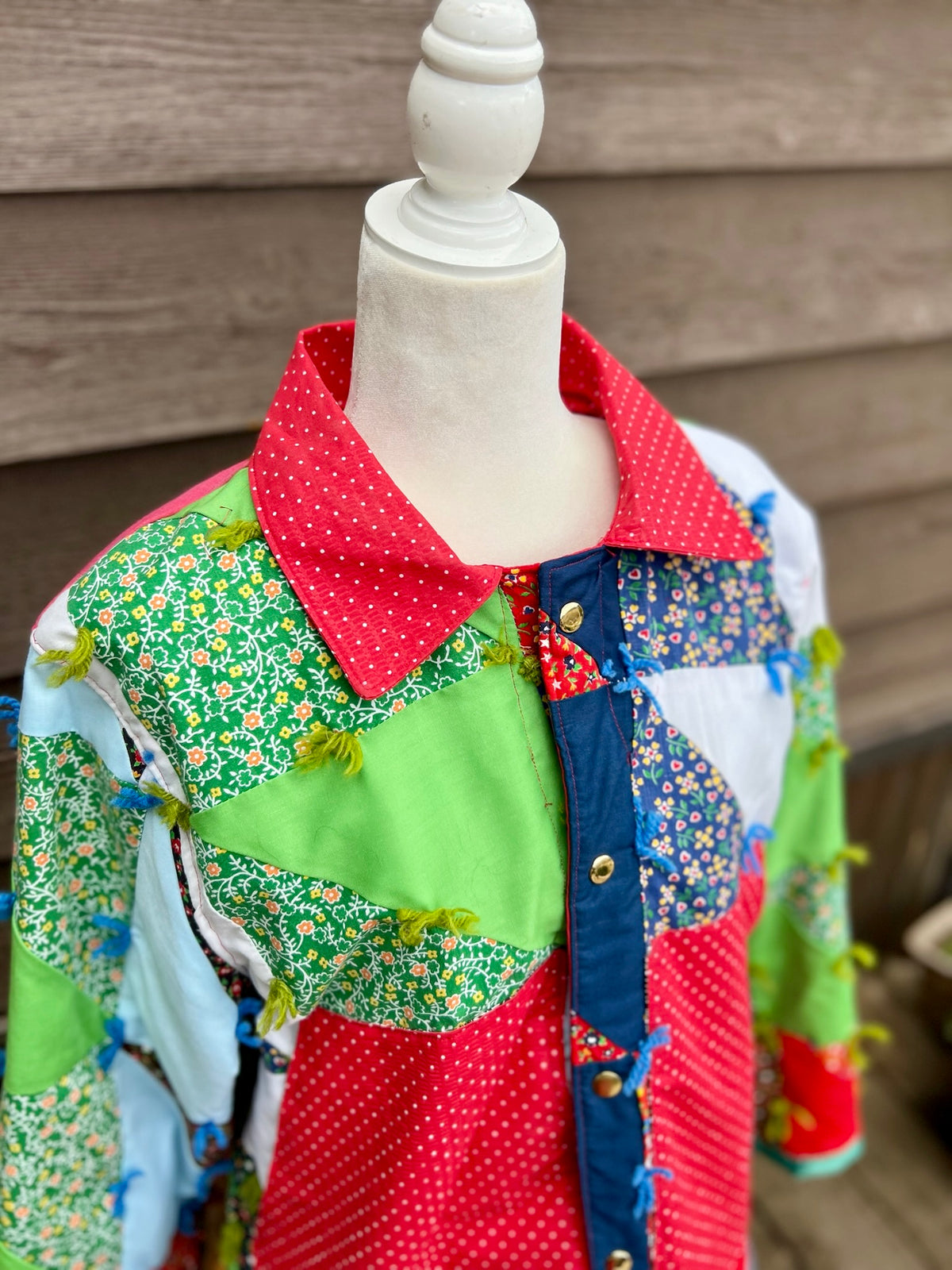 Close-up of the red collar and snap front on the vintage patchwork quilt camp coat with red collar