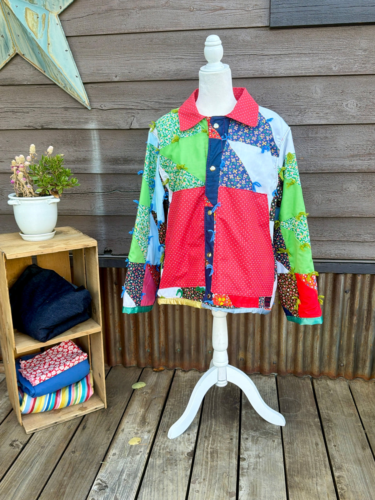 Vintage patchwork quilt camp coat with red collar on a mannequin, front view