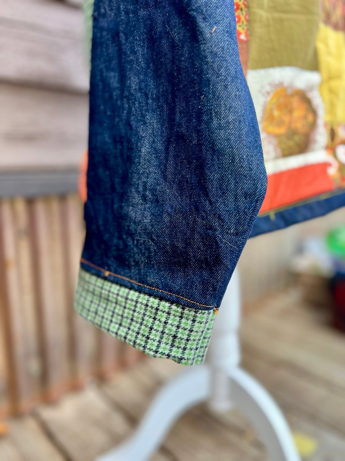 Close-up of the green check sleeve cuff n the vintage sleeping bag camp coat in yellow, brown and orange