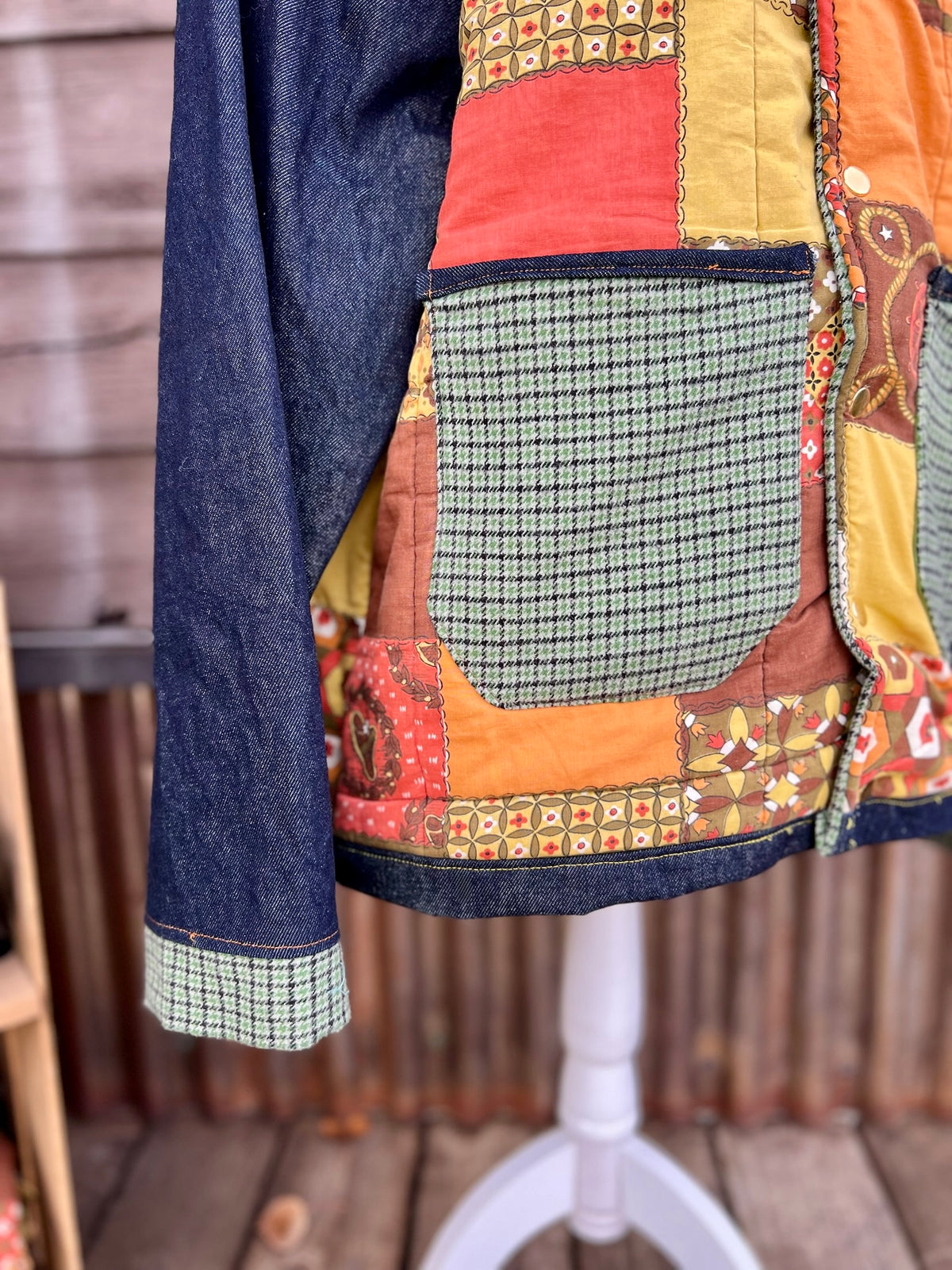 Close-up of the green check wool pockets with bias trim on the vintage sleeping bag camp coat in yellow, brown and orange