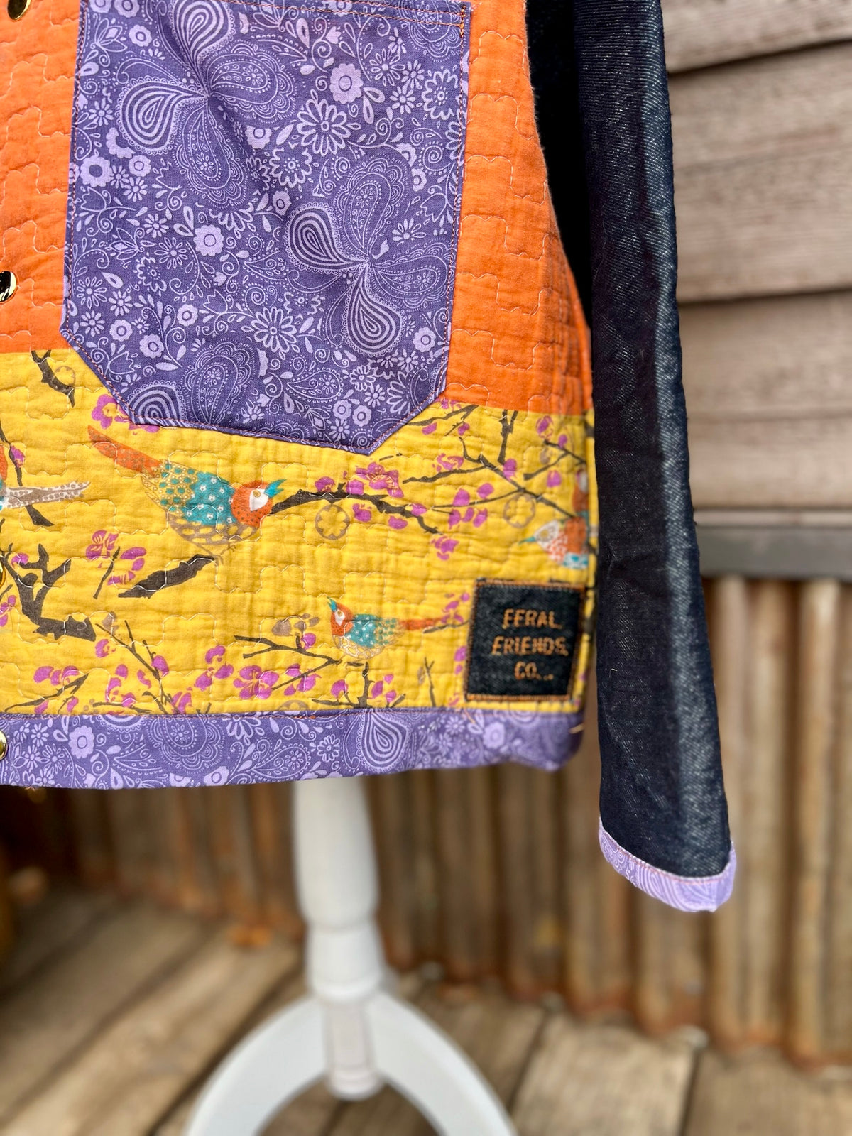 Hem of the yellow quilt camp coat with denim sleeves showing tag and handmade bias binding
