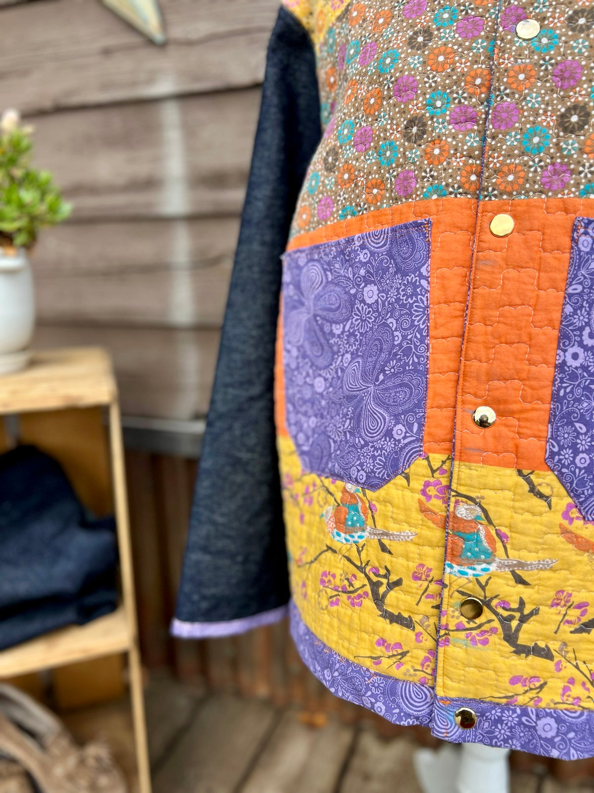 Close-up of the purple pockets with scrap fabric trim on the yellow quilt camp coat with denim sleeves
