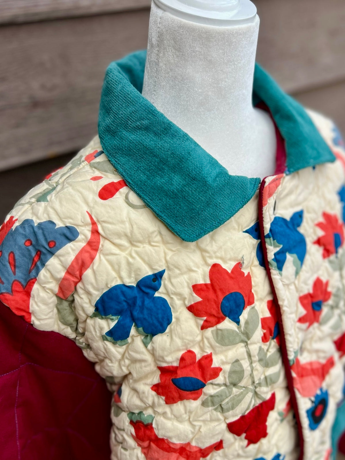 Close-up of the teal collar on the cream and seafoam floral bedspread camp coat