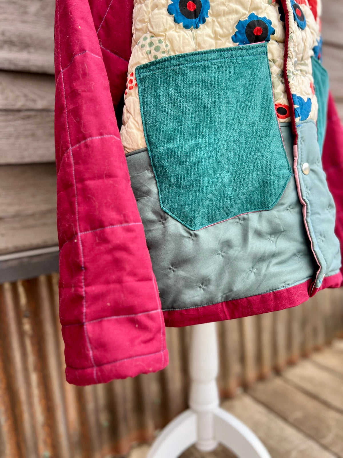 Close-up of the teal corduroy pockets on the cream and seafoam floral bedspread camp coat